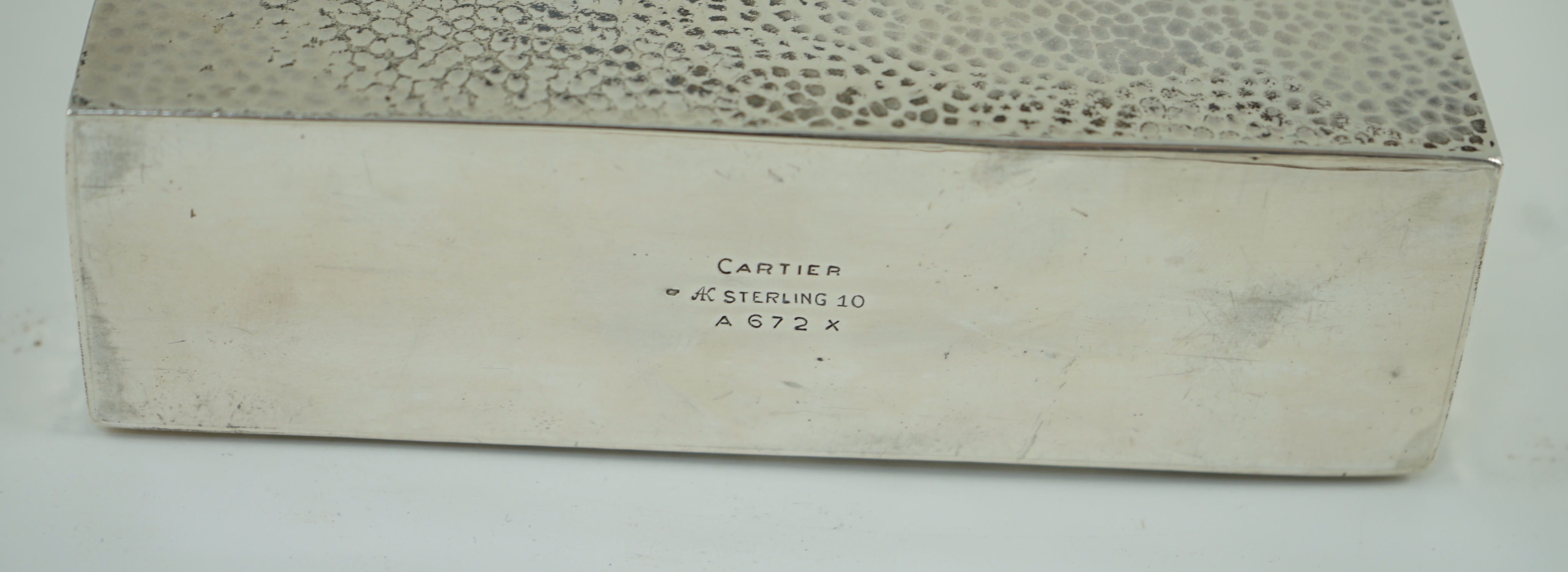 A 1930's/1940's planished sterling silver rectangular flask by Ahrendt & Kautzman, retailed by Cartier and six sterling similar graduated tots, signed Cartier